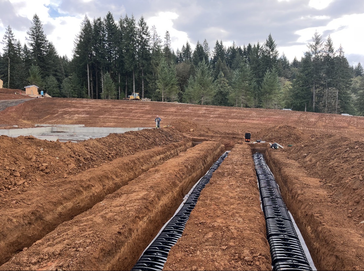 Large site development and trenching project with cleared land and underground work
