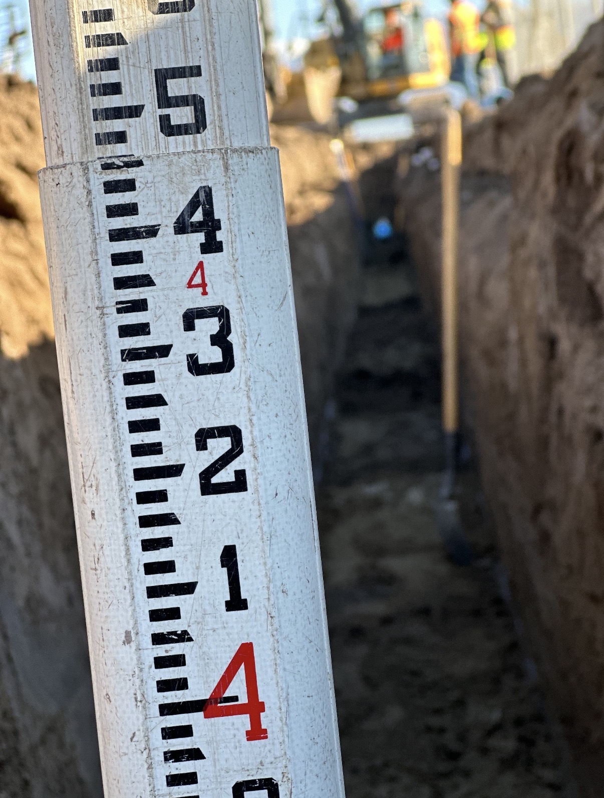 Grade stick in trench during site development and underground utility work